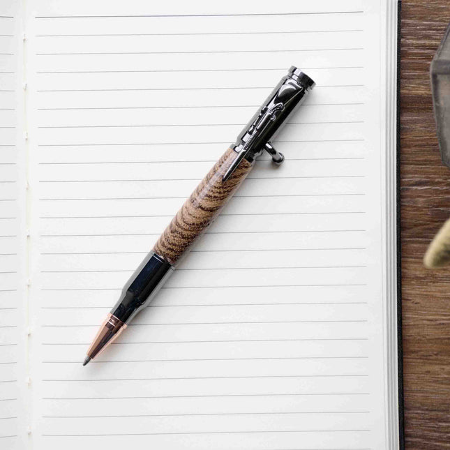 Zebrawood Bolt Action Pen by Autumn Woods Co, photographed against a white journal page