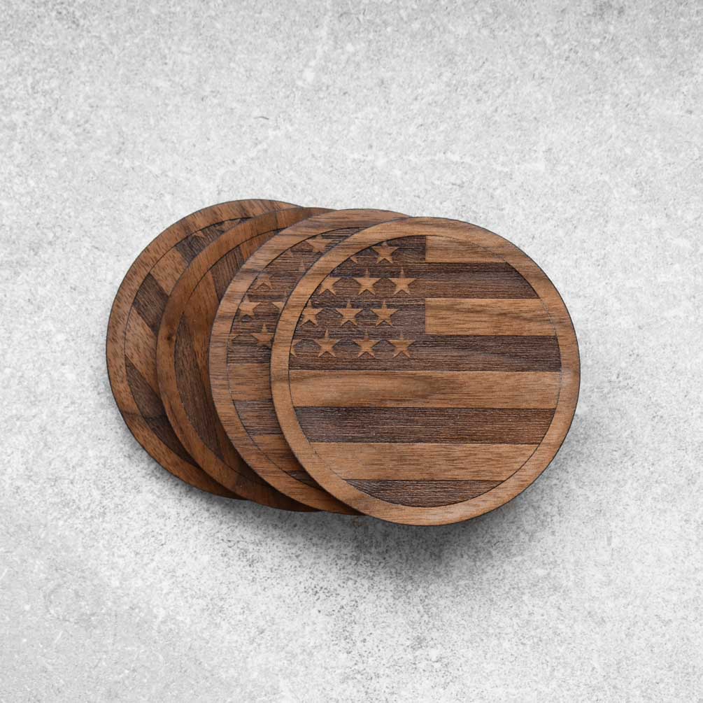 A set of 4 walnut coasters with the american flag engraved on them by Autumn Woods Co