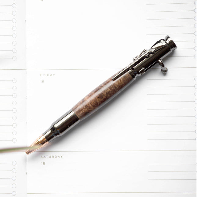 Maple Burl Bolt Action Pen photographed against a white journal page