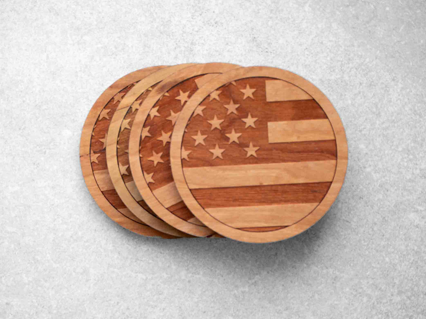 A set of 4 round cherry wood coasters with the american flag engraved on them by Autumn Woods Co
